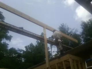 Carpenter setting a ridge beam over a new addition frame — Ice Dam Removal by Roofing Brothers in Moro