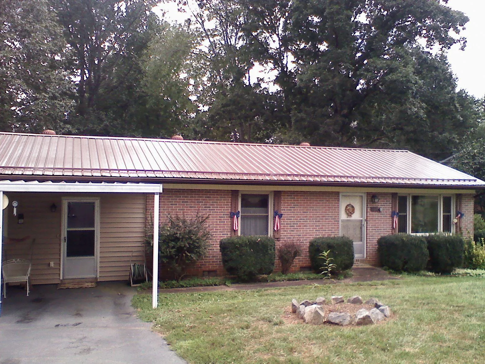 Bronze metal roof and carport on a brick ranch home — Roof Repair work by our crew in Moro